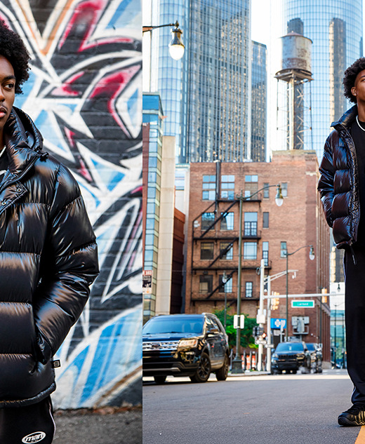 A young man wearing a shiny black puffer jacket, black pants, and sneakers stands in front of a graffiti wall (left) and on a city street with tall buildings in the background (right).