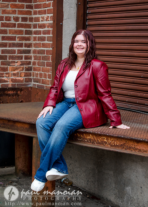Class of 2027 senior photographed against brick and industrial textures in Plymouth