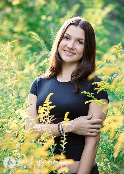Natural senior portrait surrounded by yellow wildflowers