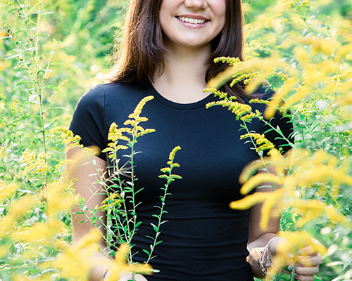 Flower field senior portrait with yellow wildflowers