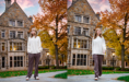 Two side-by-side photos from a fall senior pictures session show a woman in a white sweater and dark pants standing and walking outside a historic stone building with large windows, autumn trees, and a pink sunset sky.