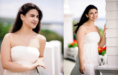 Two photos from a summer senior pictures session show a woman in a white strapless dress, standing outdoors on a bright day. She has long dark hair and is smiling in both images, with greenery and white railings behind her.