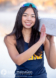 A high school senior with long dark hair smiles while holding a rowing oar on her shoulder, perfectly capturing the essence of rowing crew spirit. She wears a tank top and sunglasses on her head. The background is blurred, and a watermark with the photographer's name is at the bottom.