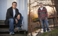 Side-by-side photos of a young man during his fall senior pictures session: on the left, he sits on wooden steps in a black coat and jeans; on the right, he stands by water in a colorful striped sweater, framed by trees and a bridge.