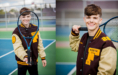 A smiling teenage boy wearing a varsity jacket holds a tennis racket on an outdoor tennis court. In one photo, he presents the racket towards the camera; in the other, he stands holding it over his shoulder.